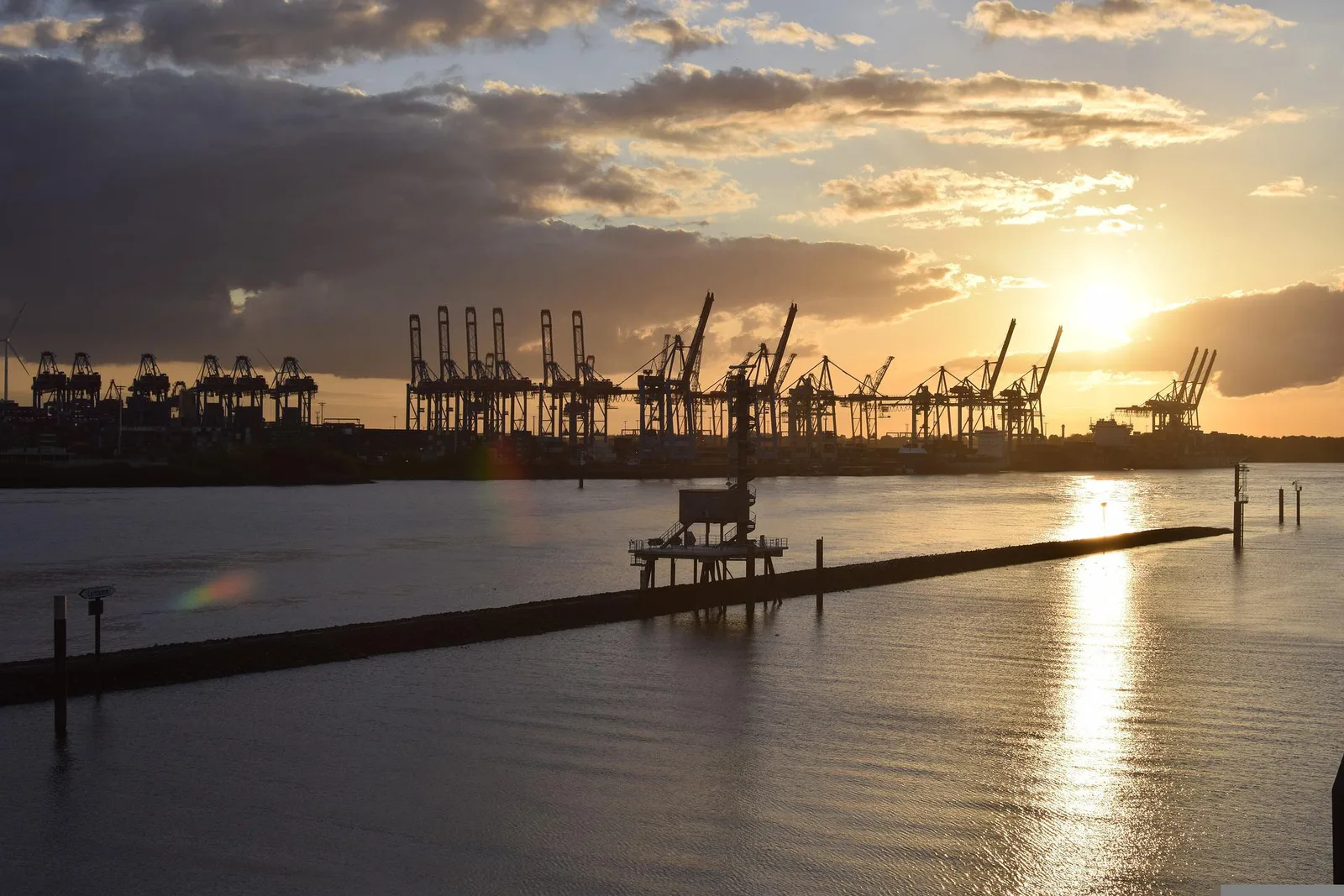 Hamburger Hafen in Abenddämmerung mit Containerbrücken und Wasser