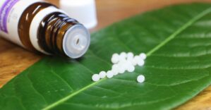 Schüßler Salze Flasche mit weißen Tabletten auf grünem Blatt