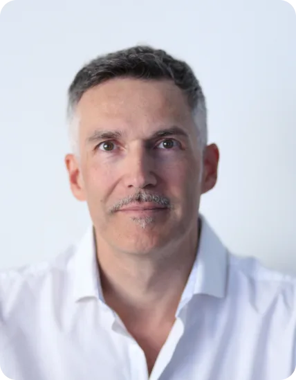 Porträt Reinhard Clemens, Autor und Naturheilpraktiker, weißes Hemd vor hellem Hintergrund
