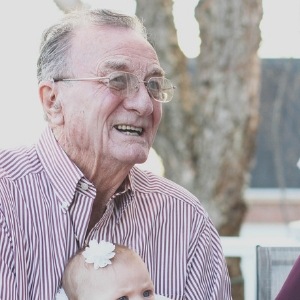 Älterer Mann mit Brille und rosa Hemd lachend, Kundenbewertung