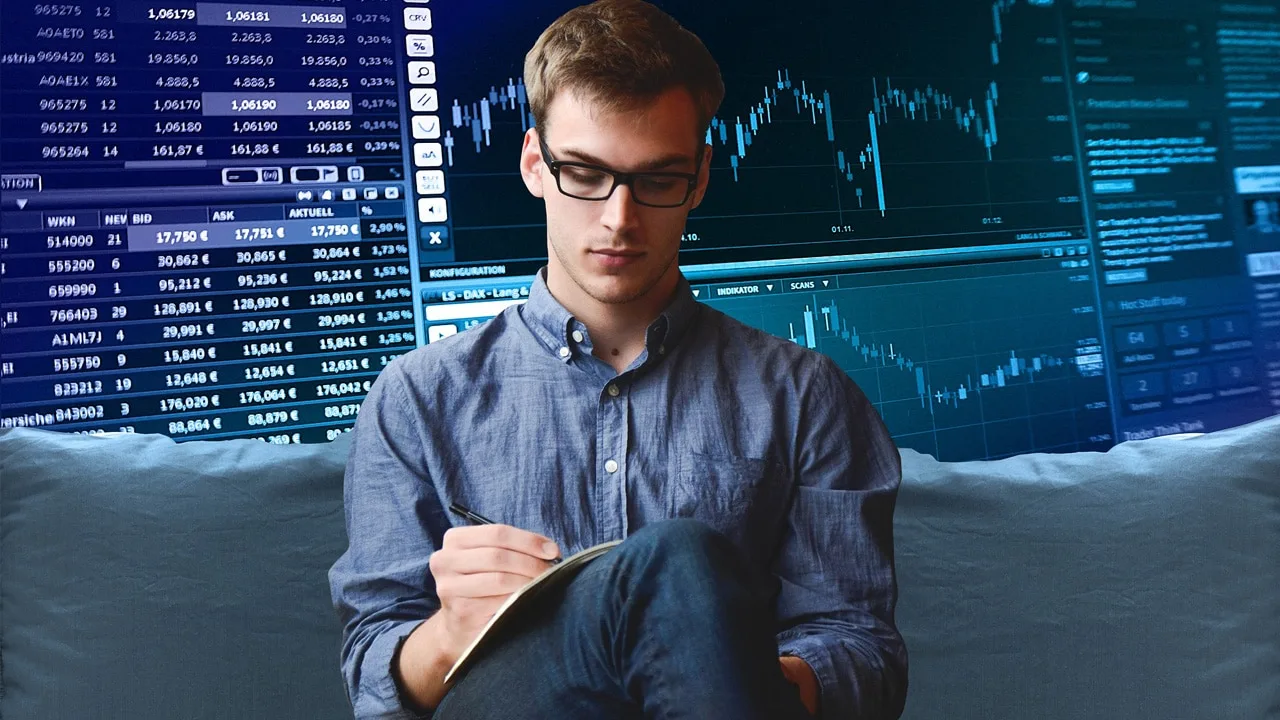 Junger Mann mit Brille analysiert Aktiendaten und Charts am Laptop