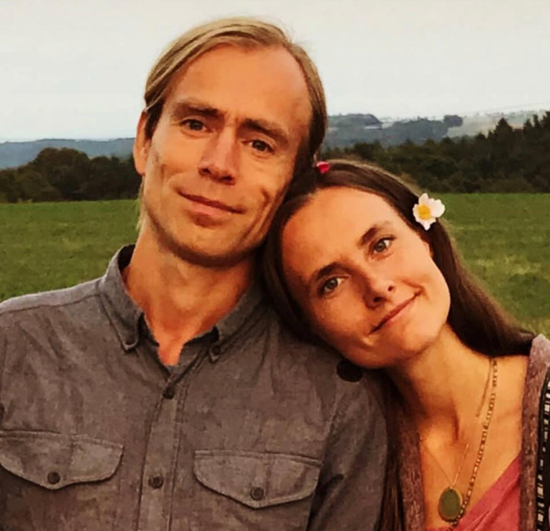 Junges Paar in Landschaft mit Bergen im Hintergrund, Frau mit Blume im Haar