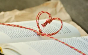 Hochzeitsplanung für Anfänger Buch-Cover mit roten und goldenen Schnüren in Herzform auf aufgeschlagenem Buch