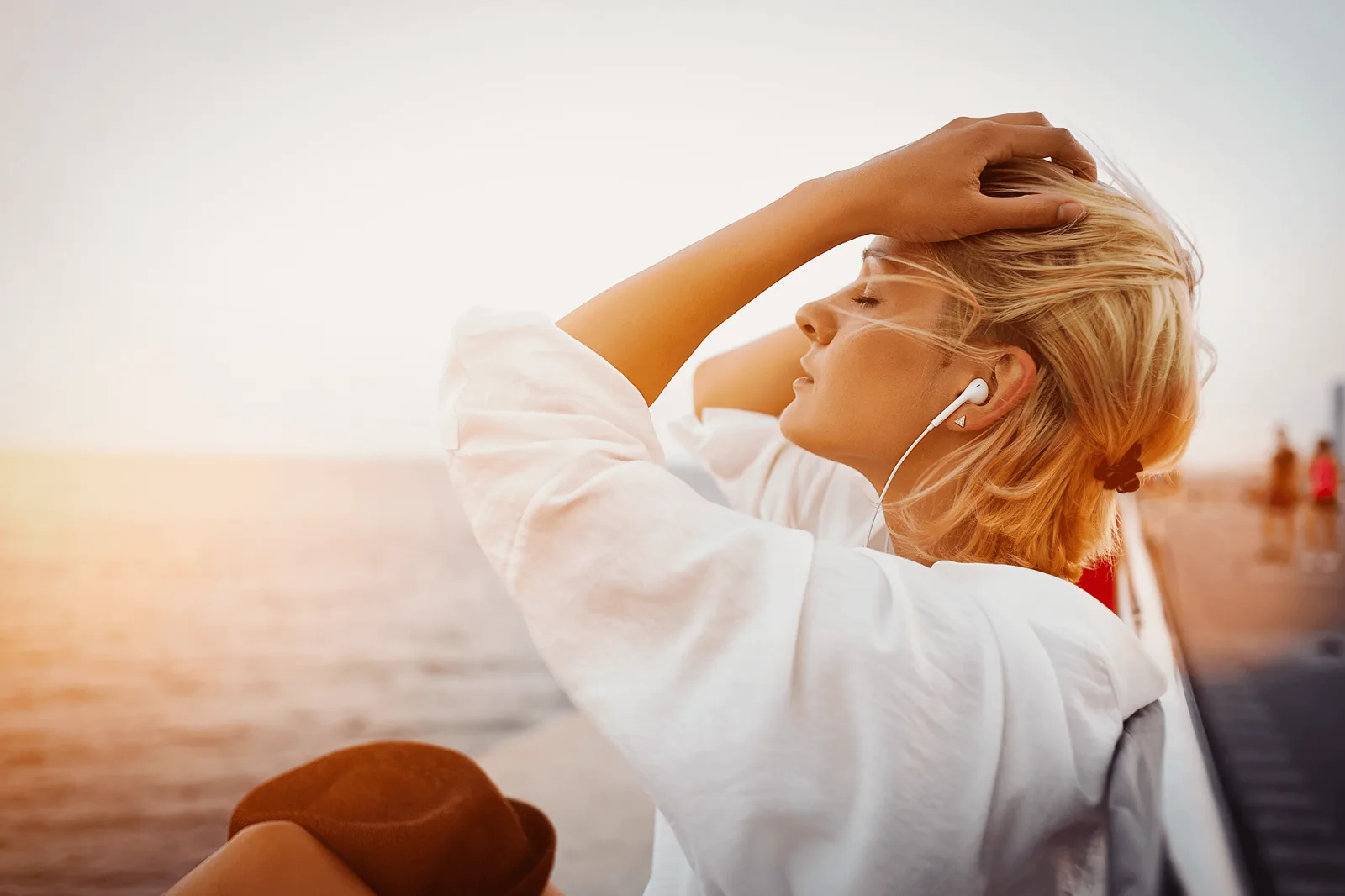 HOME – Geführte Trance-Audios für Trance & Meditation von André Loibl 4 Frau mit rötlichen Haaren am Strand mit Kopfhörern, entspannt, Himmelsblick