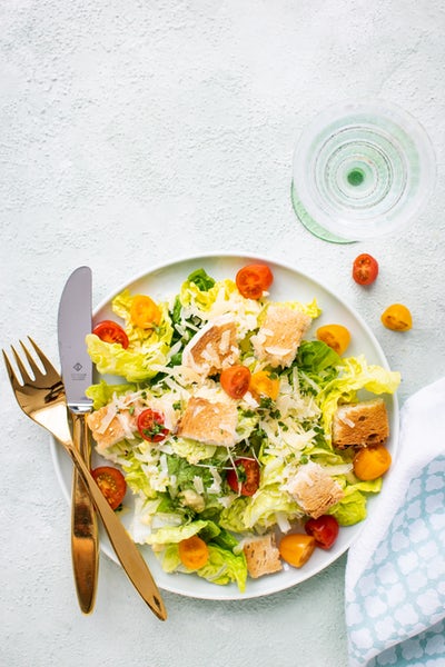 Gemüsesalat mit Lachs und bunten Tomaten auf weißem Teller von oben