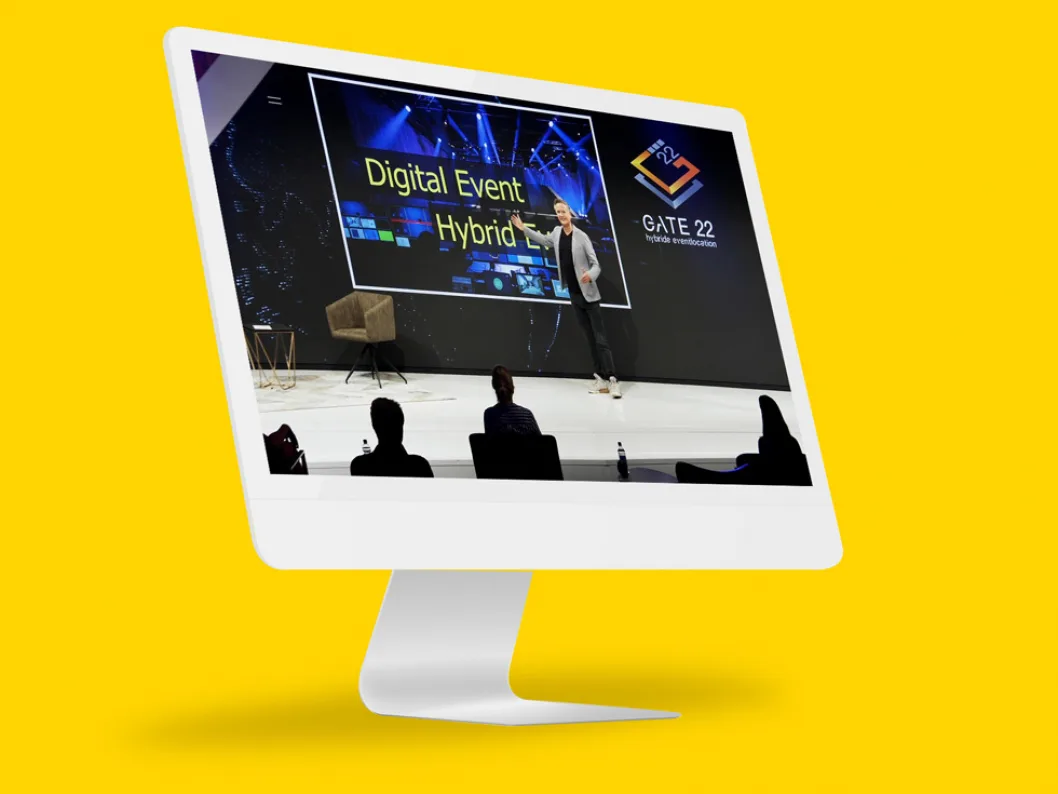 Monitor zeigt Digital Event Hybrid Event mit Sprecher und Publikum