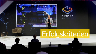 Moderator auf Bühne mit Text Erfolgskriterien