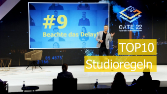 Moderator auf Bühne mit Text TOP 10 Studioregeln