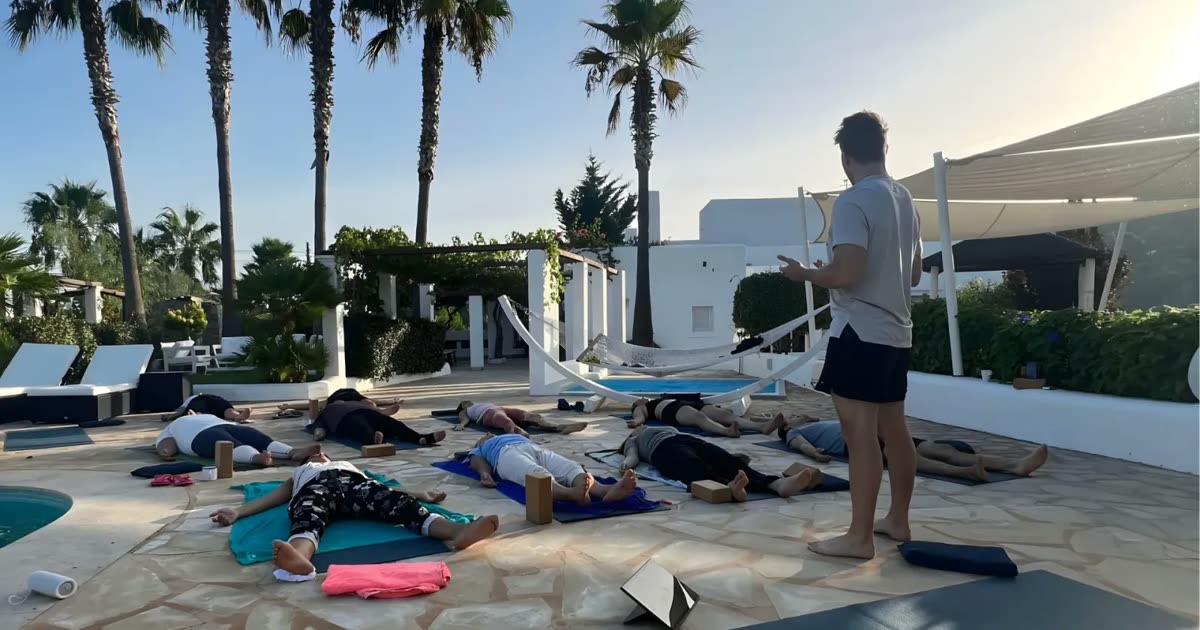 Hypnobreath Gruppenmeditationssitzung im Freien mit mehreren Teilnehmern auf Matten unter Palmen