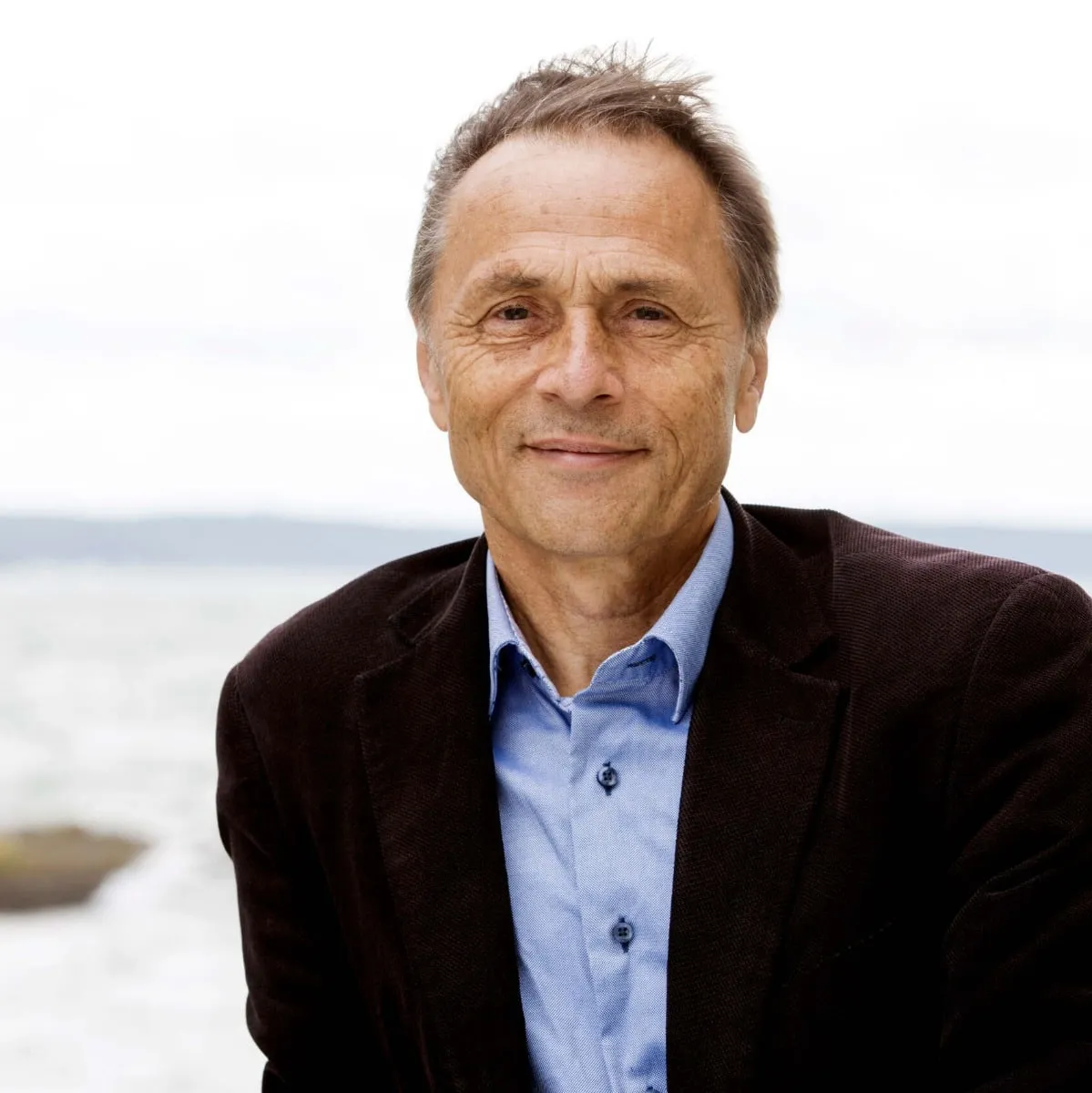 Porträt Dr. Audun Myskja mit braunem Jackett und blauem Hemd am Meer