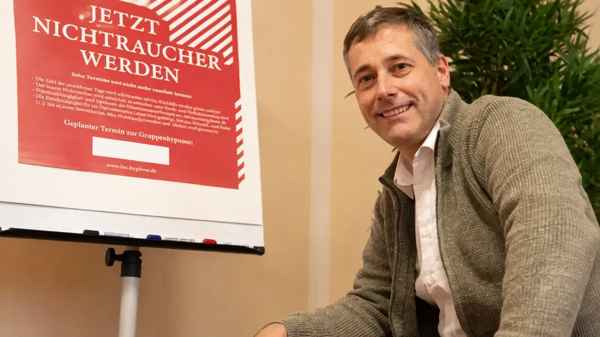 Tobias Paul neben IHC Poster zur Raucherentwöhnung