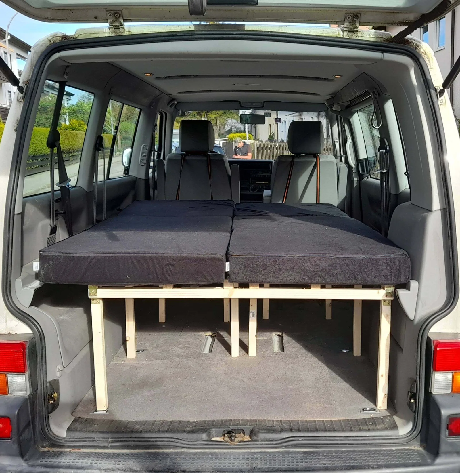 VW T6 Transporter mit entfaltetem Doppelbett auf Holzgestell