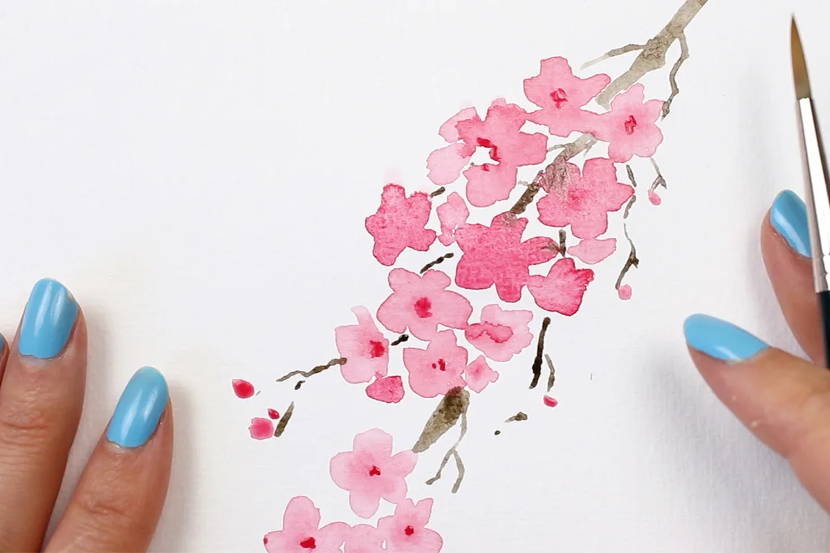 Aquarell Kirschblüten Zweig mit zartrosa Blüten an braunem Ast, Hand mit blauer Nagellackierung