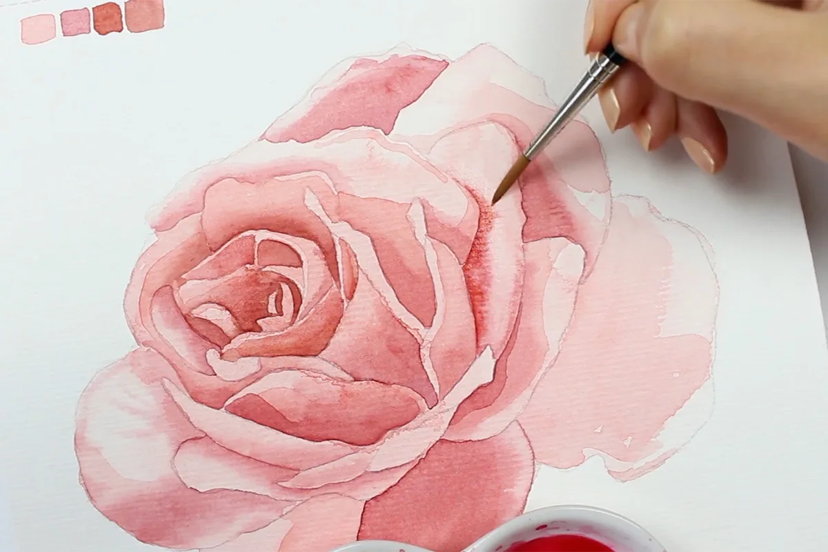 Aquarell zartrosa Rose in Arbeit mit Pinsel und Aquarellpalette, Farbmusterquadrate oben