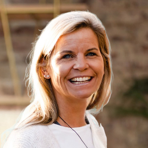 Porträt von Christine Kühnel, blonde Coach mit strahlendem Lächeln