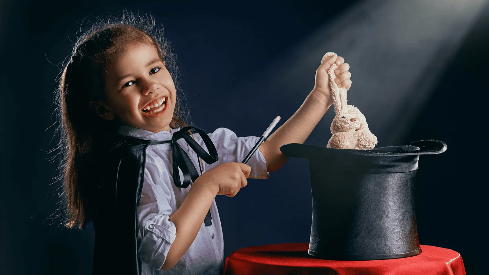 Mädchen zaubert begeistert mit Kaninchen aus Zylinder, Zaubershow für Kinder