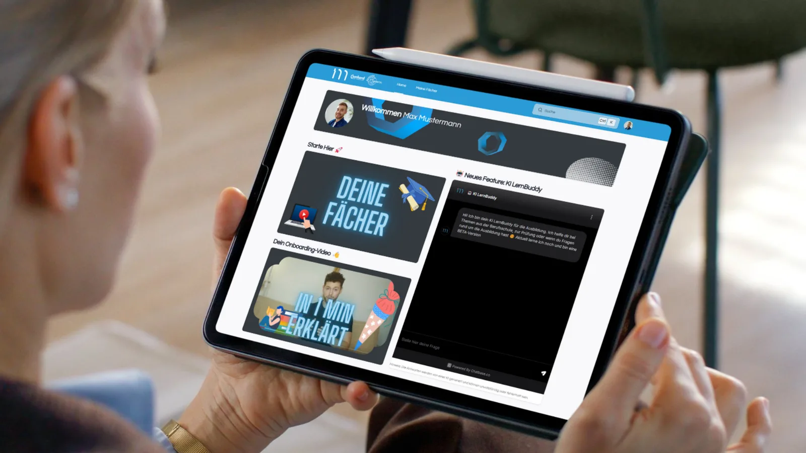 Tablet in Händen zeigt Startseite MyDigiAcademy mit Willkommensmitteilung, KI-LernBuddy-Feature, Fächerauswahl und Onboarding