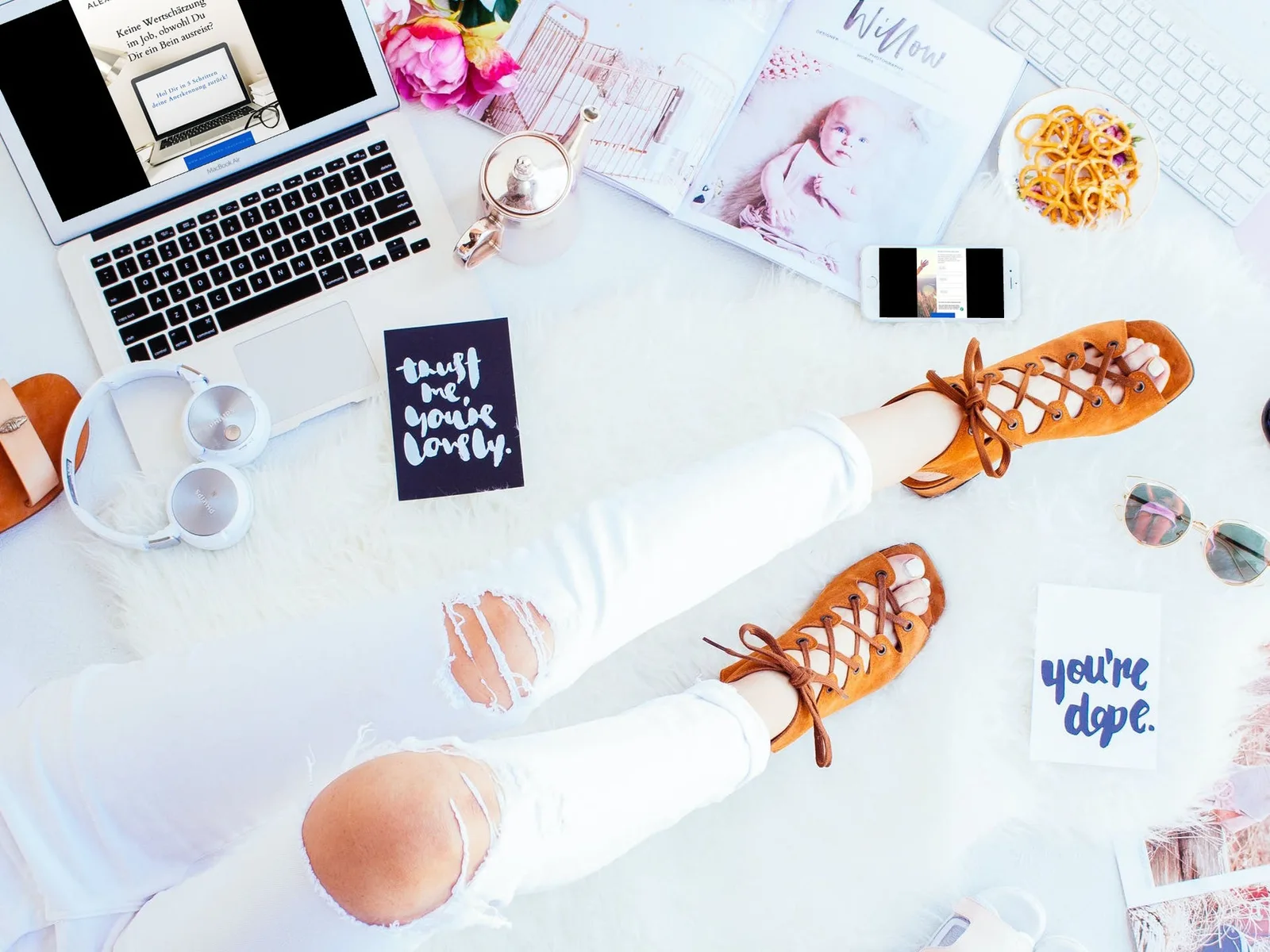 Flat-Lay Arbeitsplatz mit Laptop, Workbook, Blumen und Accessoires in Pastell-Tönen