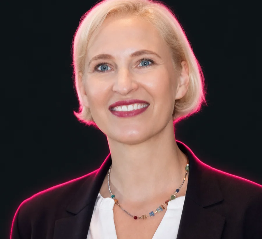 Katrin Friedel, Expertin, Portrait mit neonpinkfarbener Randbeleuchtung vor schwarzem Hintergrund