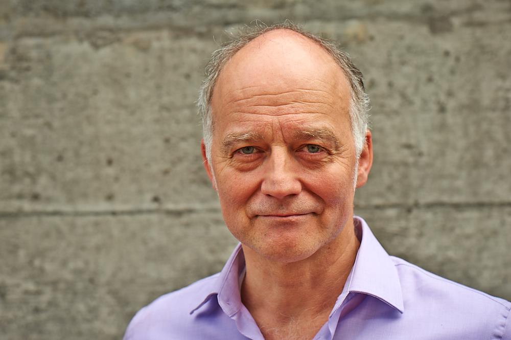 Kickstart Passives Einkommen – Buch zum Online-Business-Aufbau 13 Holger Eckstein Porträt in lila Hemd vor Betonwand