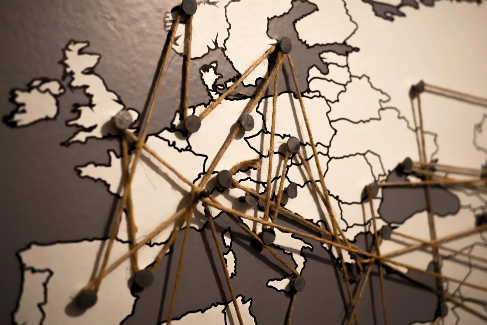 Europakarte mit Fadennetzwerk und Pins, die Verbindungen zwischen Ländern zeigen