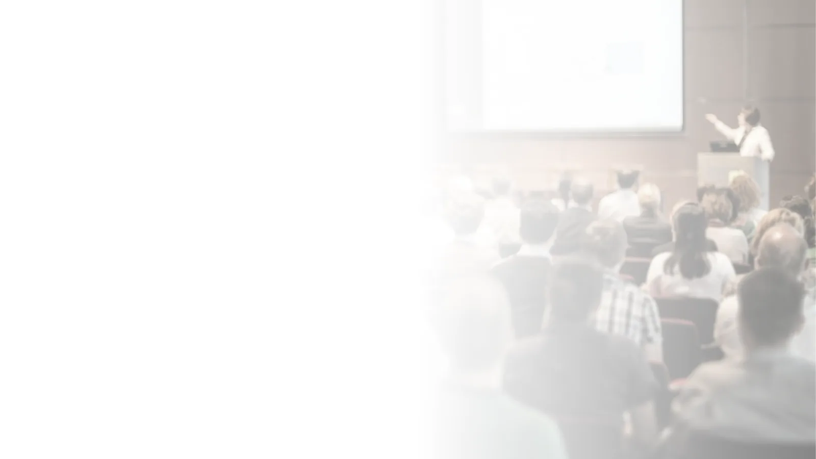 Standbild einer Konferenz mit Referent am Rednerpult und Publikum im Saal