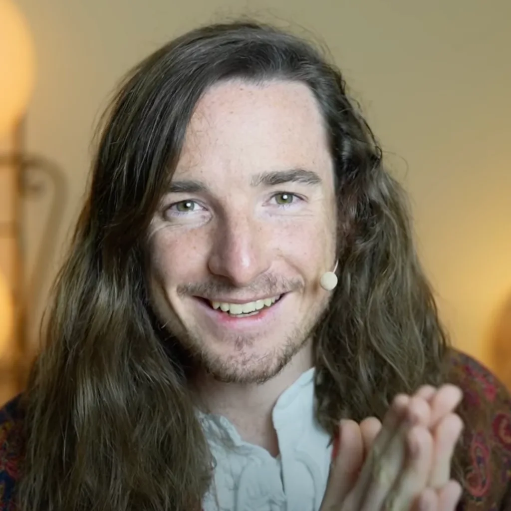 Robin Kaiser, Mann mit langen dunklen Haaren, weißem Hemd, lächelnd