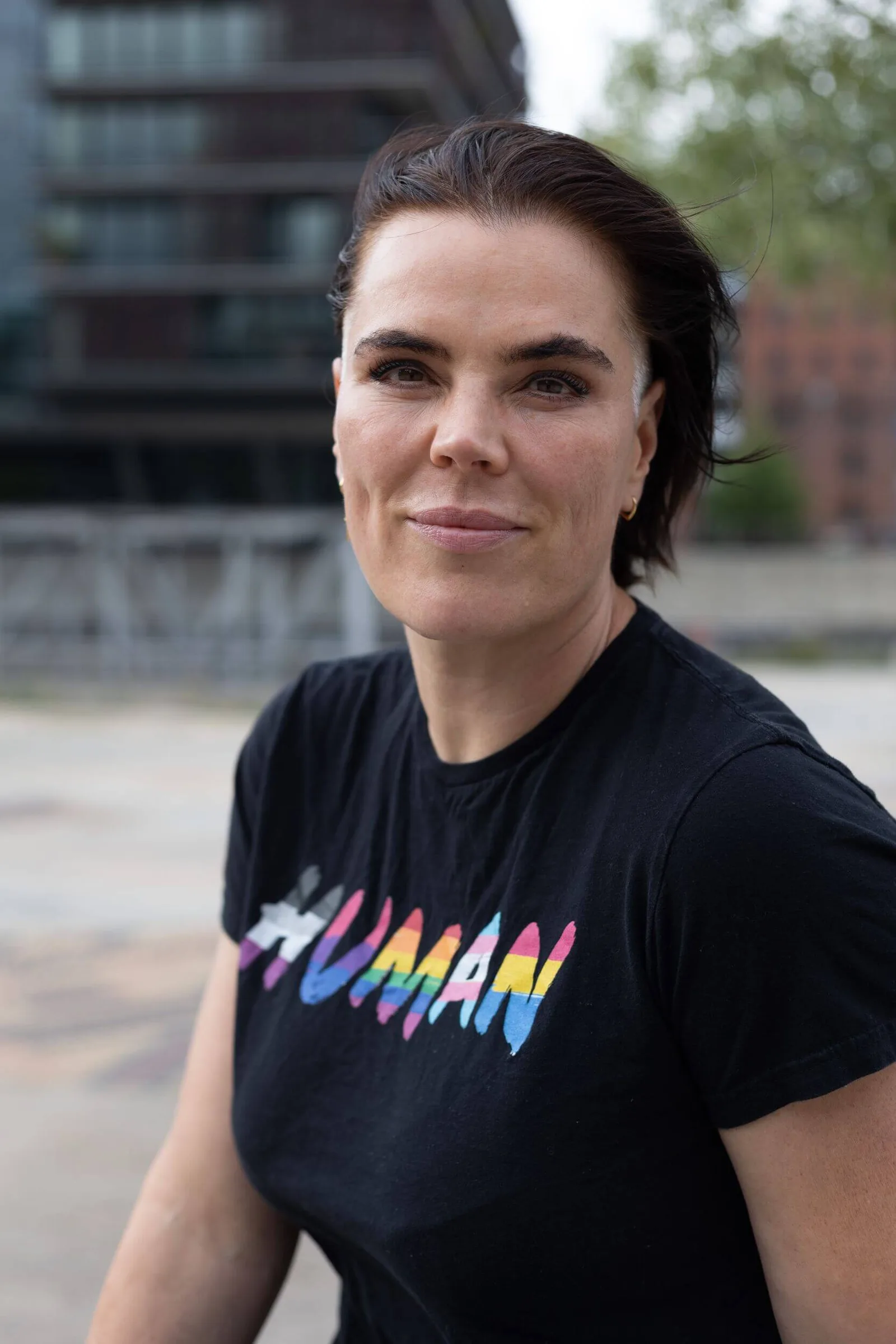 Porträt von Frau mit buntem Grafik-Shirt vor Urban-Hintergrund