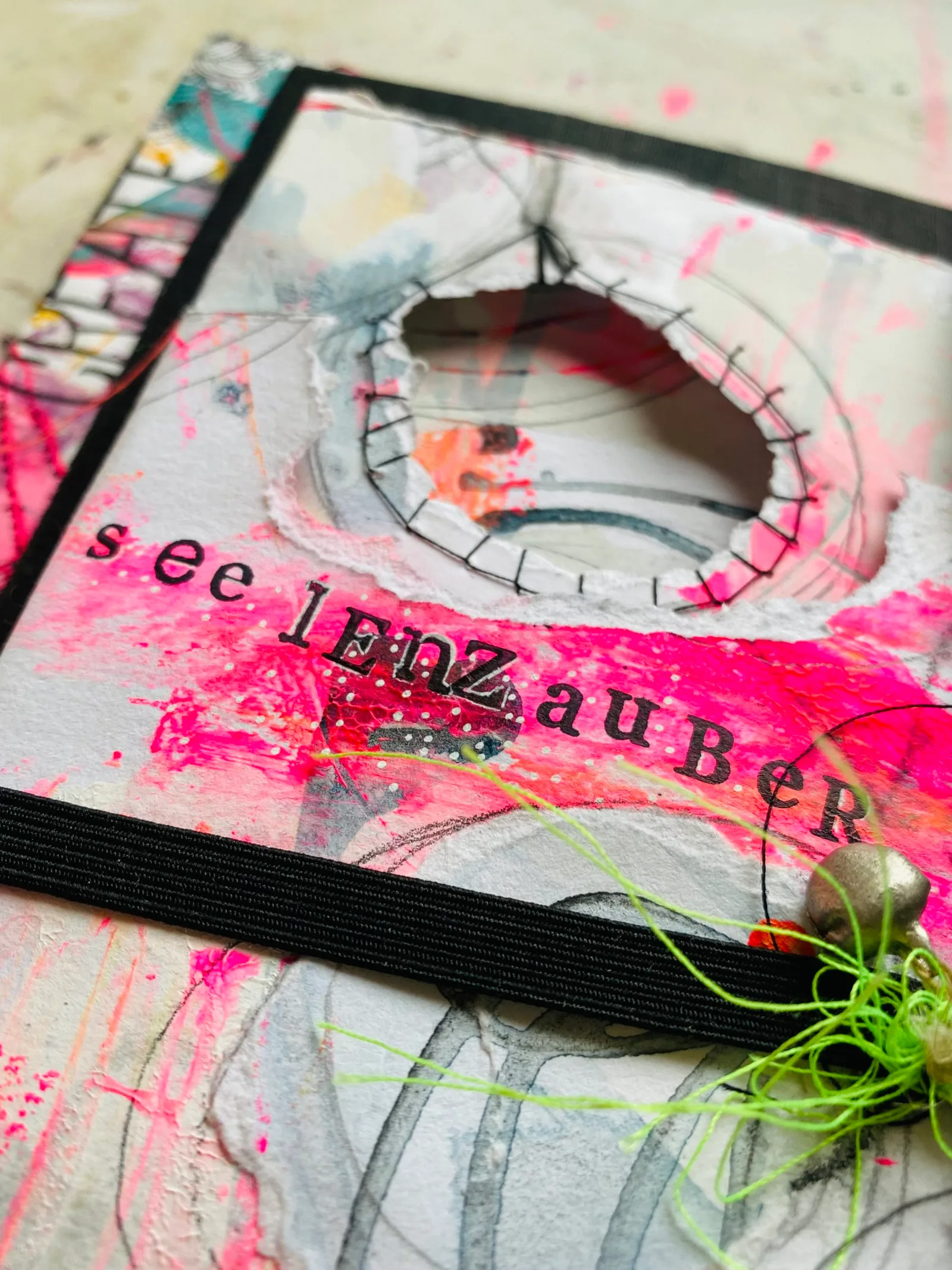 See Lenzauber Notizbuch-Cover mit rosa-weißem Mixed-Media-Design