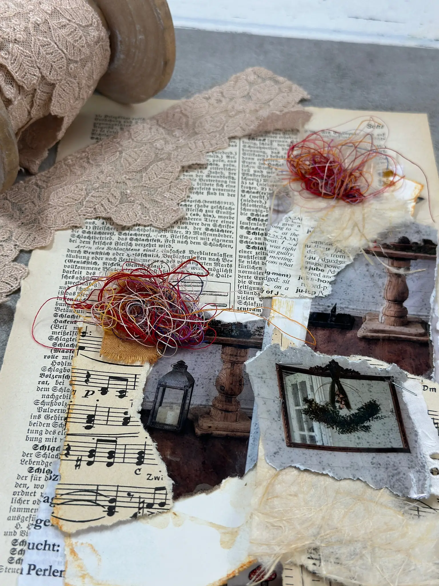 Collage mit rotem Draht, Nostalgiefotos, Musiknoten und Buchseiten auf Leinen
