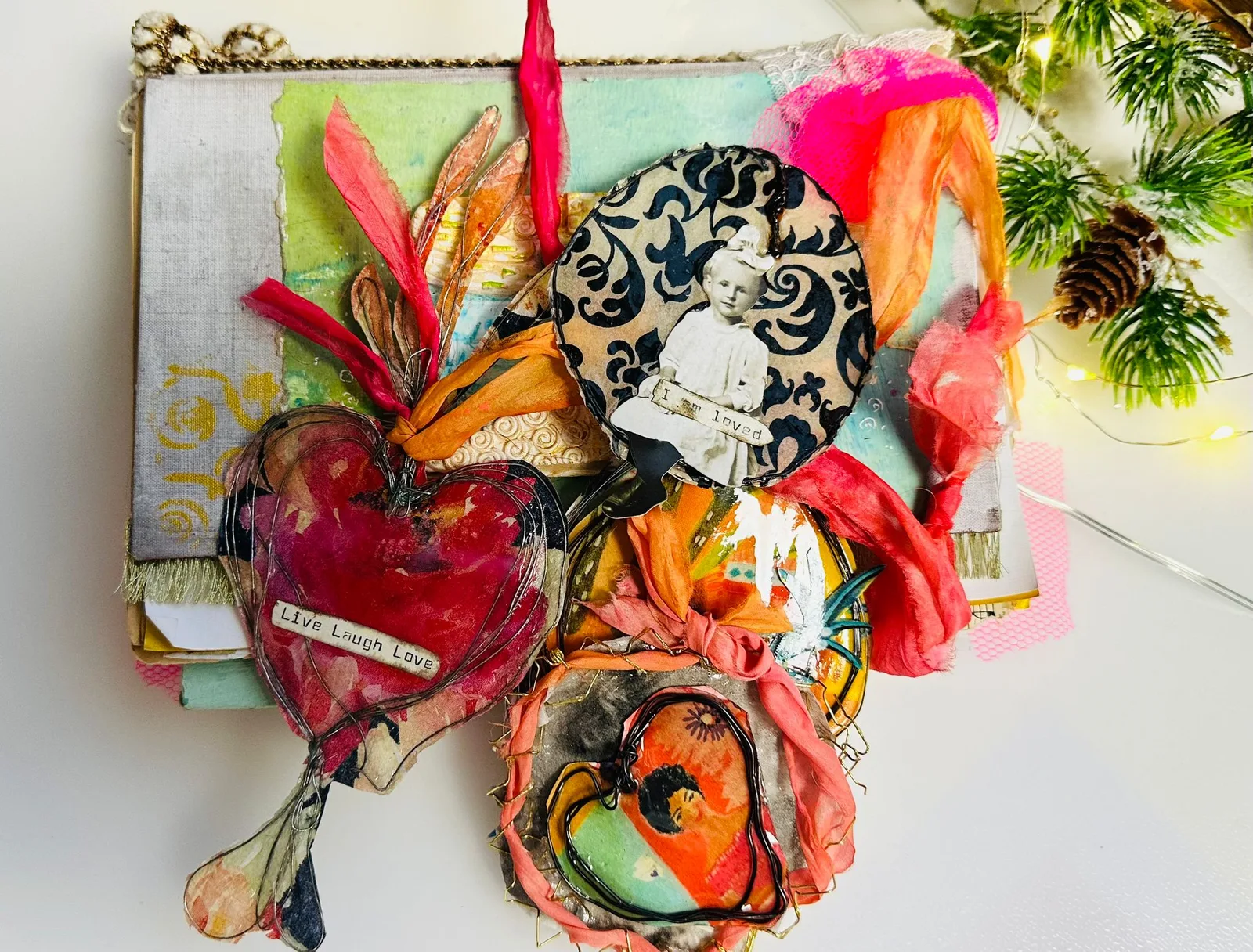 Mixed-Media-Kunstobjekt mit farbigen Drähten, Federn, Fotos und Herz-Form mit Text 'Live Laugh Love'