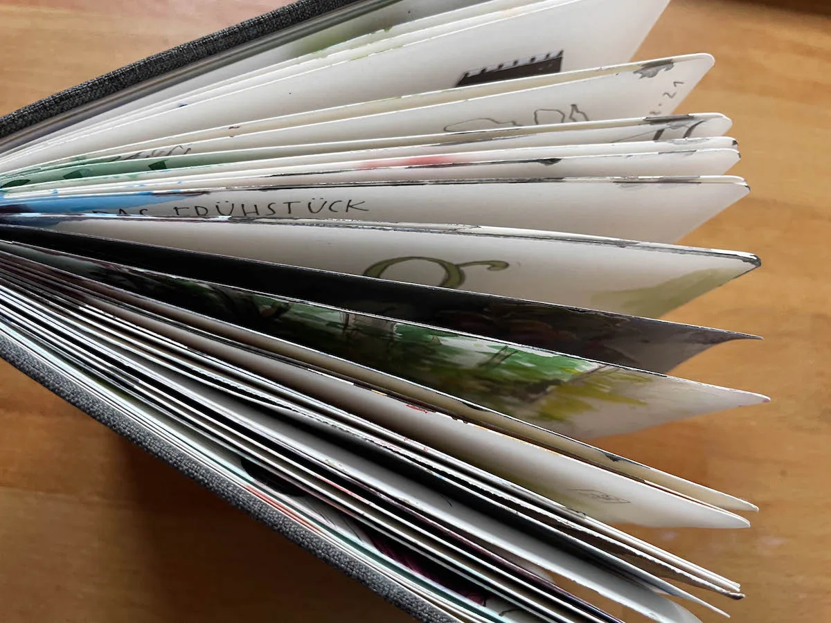 Offener Ringordner mit gestapelten Blättern und handschriftlichen Notizen auf Holztisch