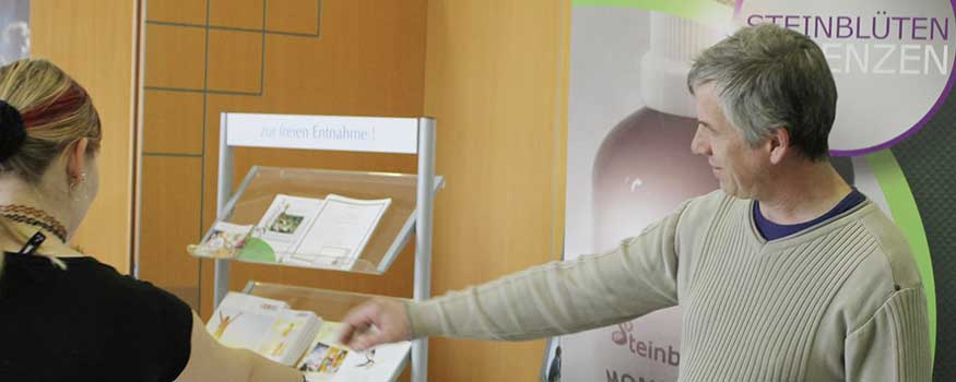 Mann und Frau bei Lebensthemen-Austestung mit Informationsmaterial auf Tisch