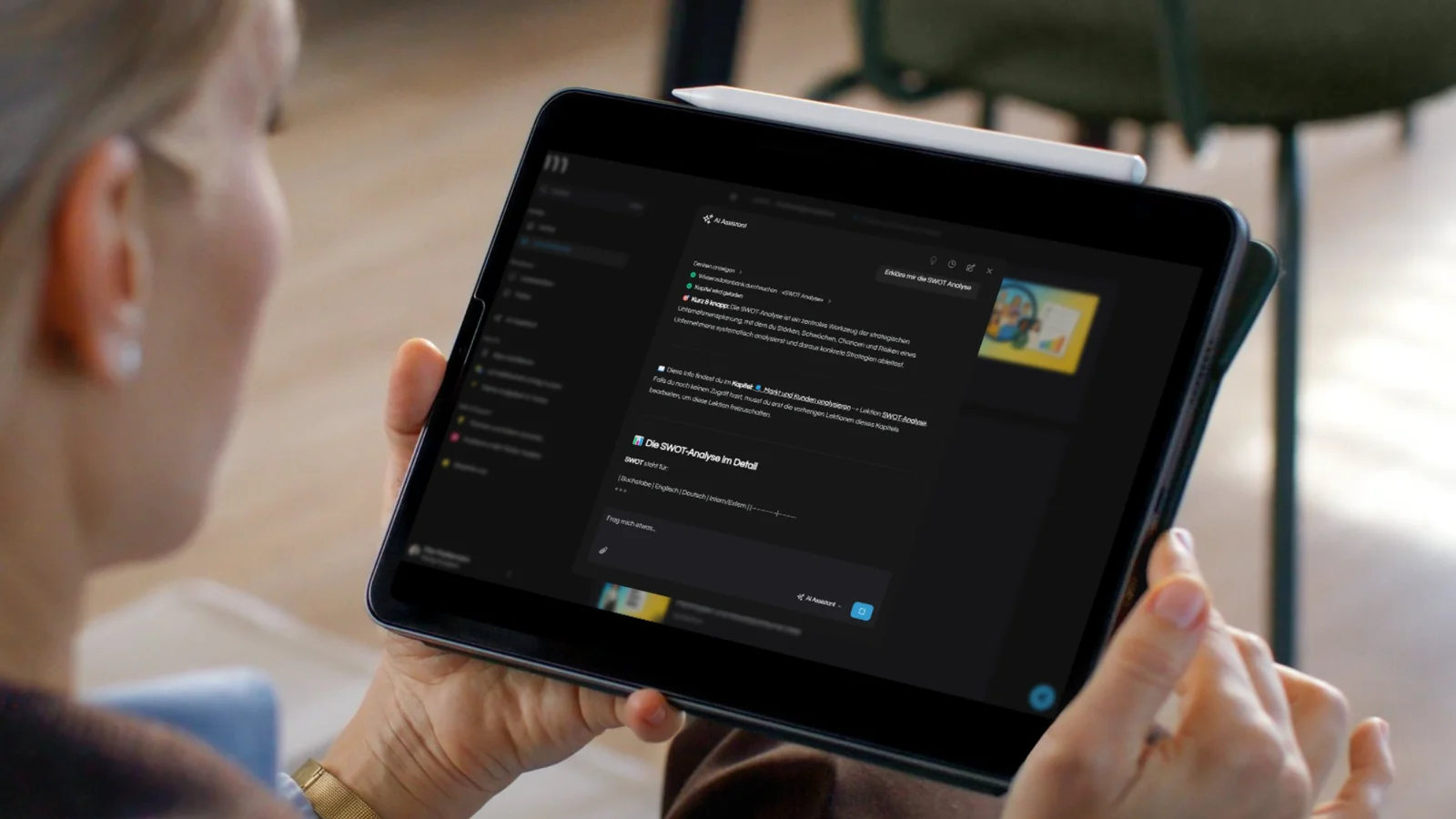 AI Assistent auf Tablet erklärt SWOT-Analyse mit verlinkter Lektion und Video-Thumbnail