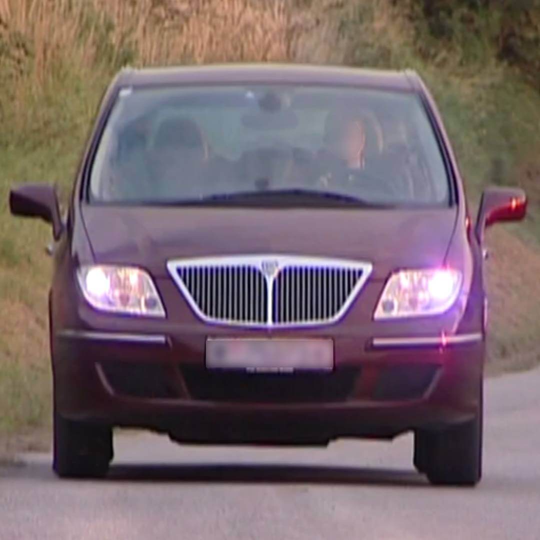 Lancia Phedra Minivan in Violett, Frontansicht mit eingeschaltetem Licht
