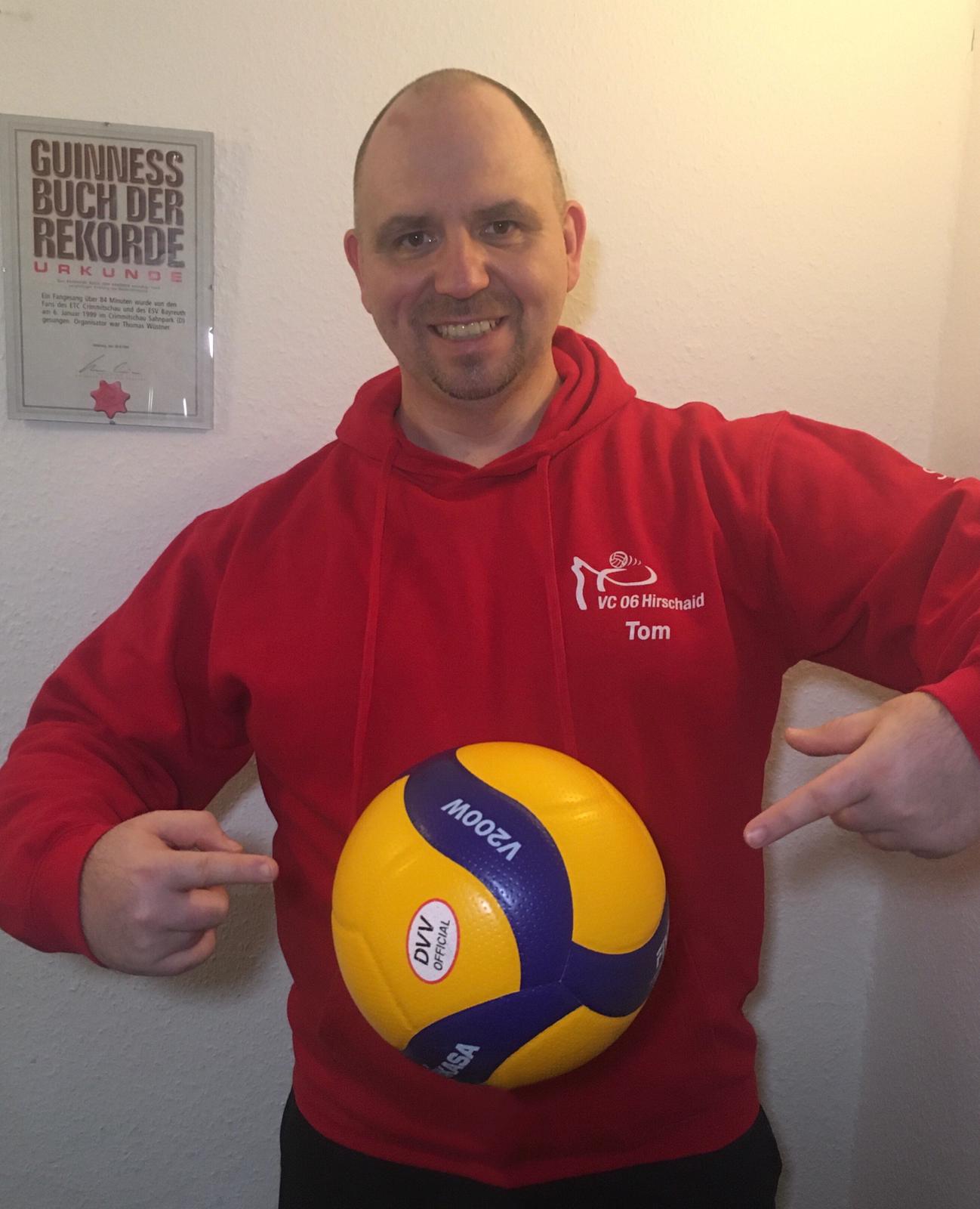 Thomas Wüstner mit Volleyball in rotem Hoodie vor Guinness-Urkunde