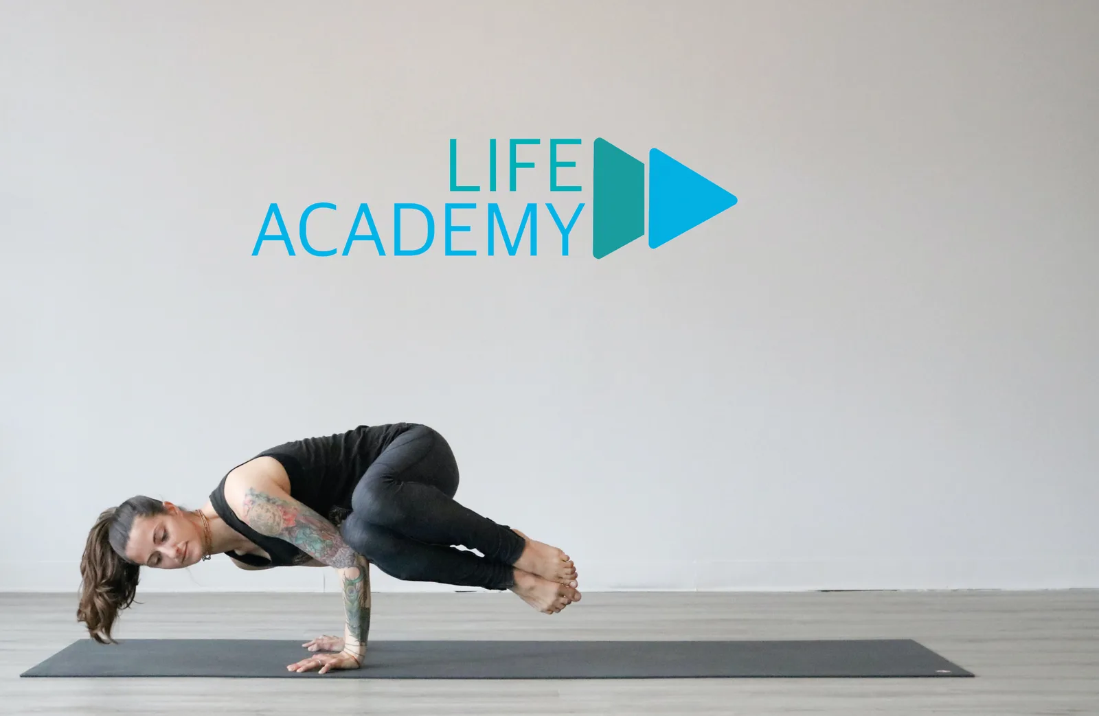 Life Academy Logo mit Play-Symbol und Frau in Yoga-Position auf grauem Hintergrund