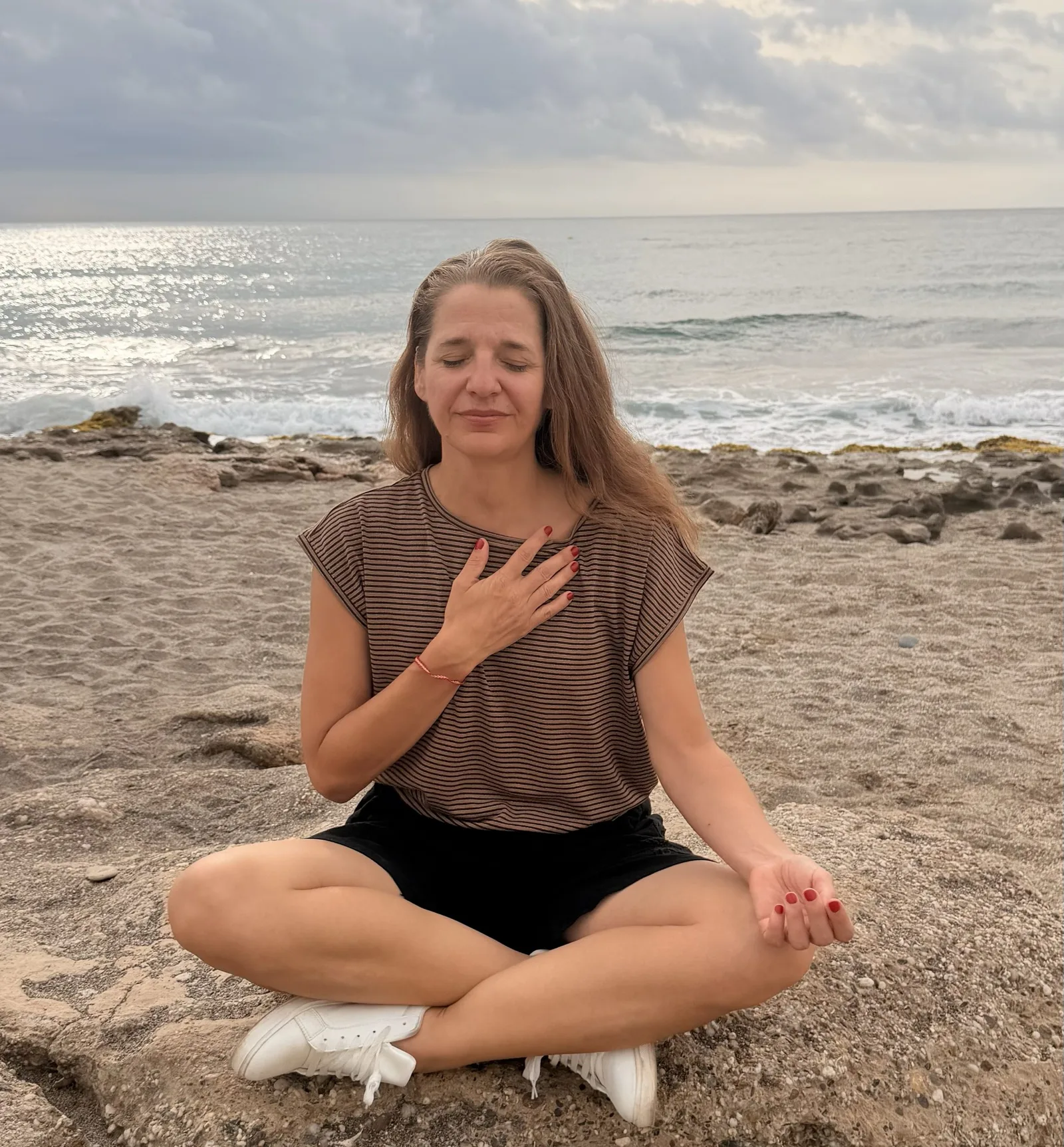 Dr. Katrin Hegendörfer meditierend am Strand im Atemkurs