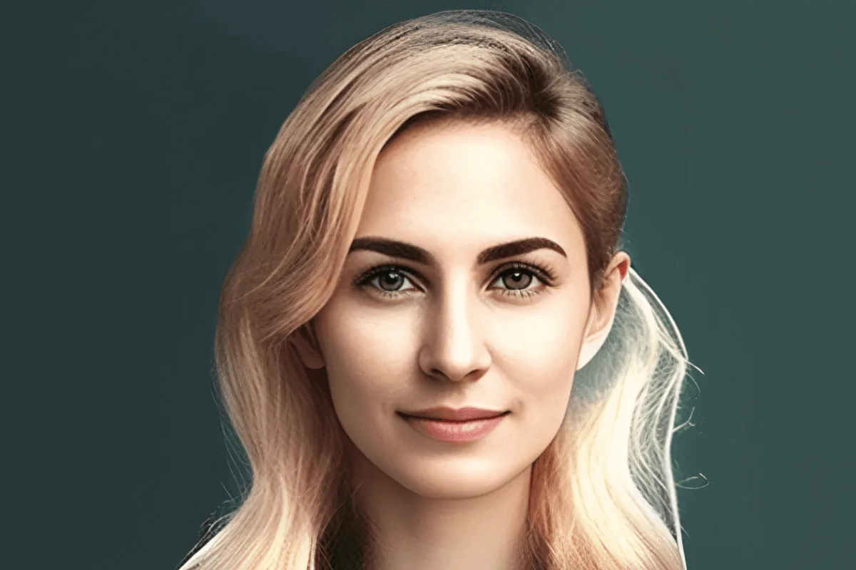 Porträt einer Frau mit hellem Haar, sanftem Blick vor graugrünem Hintergrund
