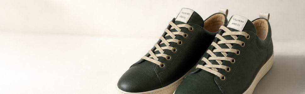 Zwei grüne Sneaker mit cremefarbener Sohle und Schnürung frontale Ansicht