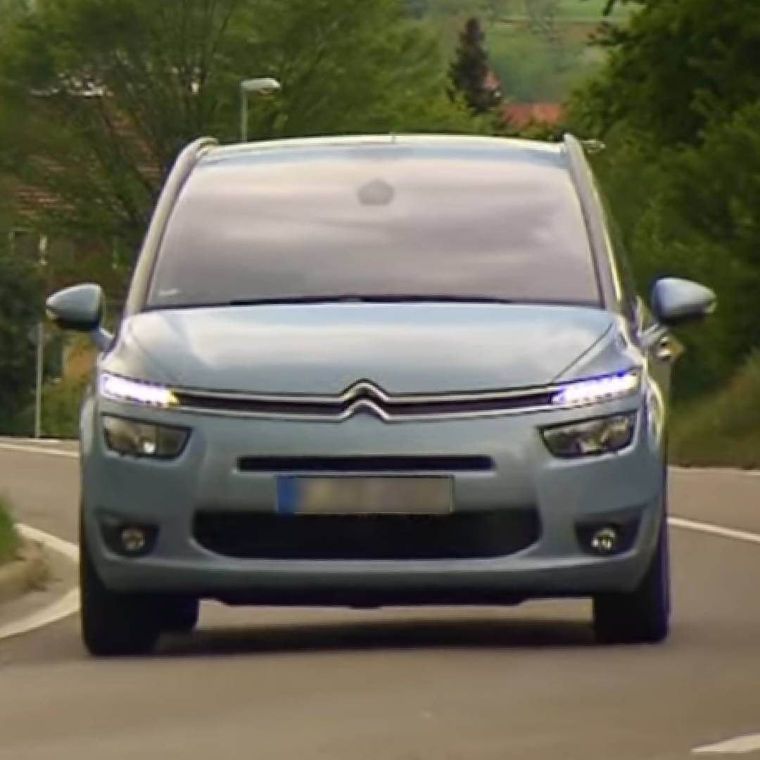 Citroen C4 Grand Picasso silberfarben, Frontansicht auf Straße mit Bäumen im Hintergrund