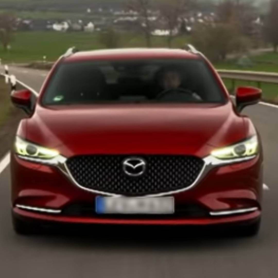 Roter Mazda6 Kombi III Frontansicht auf Straße mit grüner Landschaft