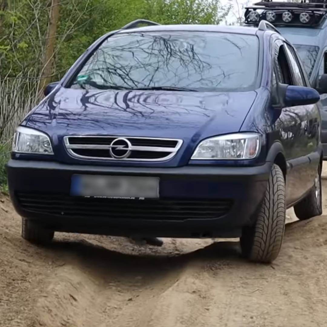 Opel Zafira A dunkelblau von vorne, geparkt auf Schotterplatz mit Wald im Hintergrund