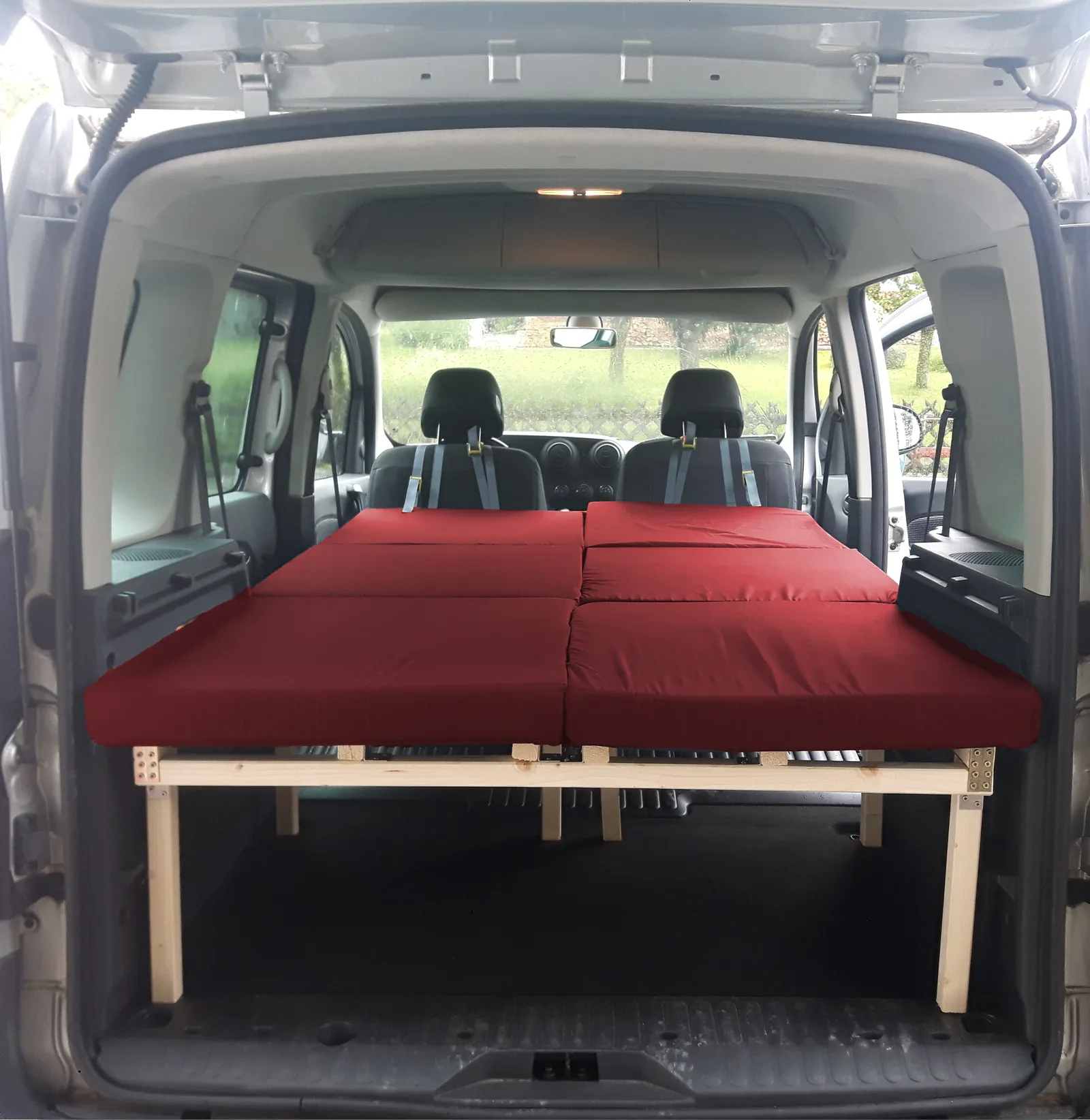 Peugeot Rifter mit ausgezogenem roten Doppelbett, Innenansicht des Fahrzeugs