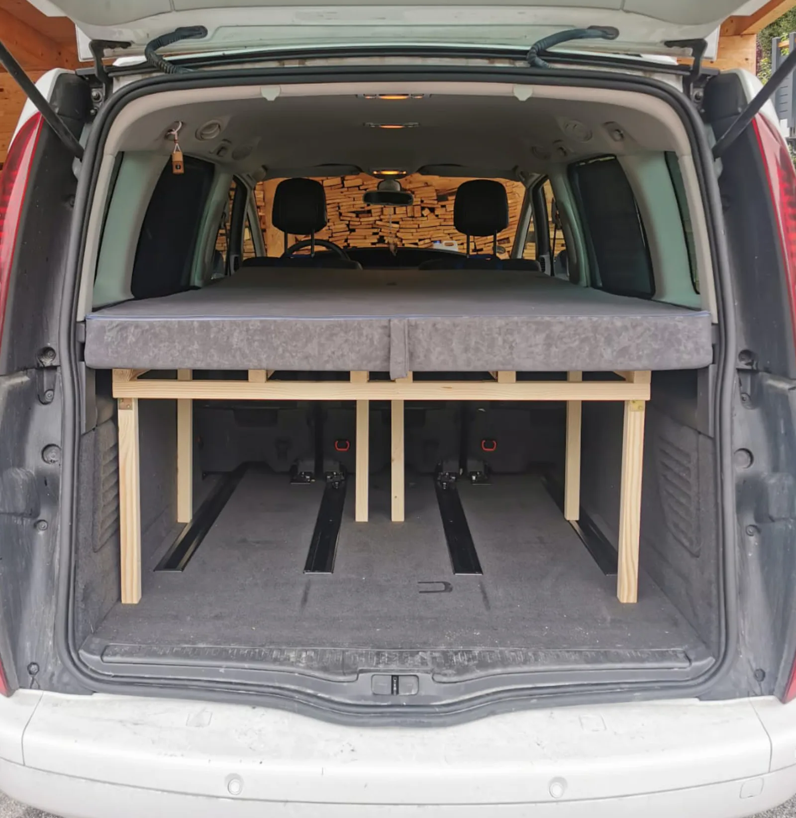 Renault Espace IV Kofferraum mit ausgebautem Holzbett und grauer Matratze, Dachträger mit Boxen