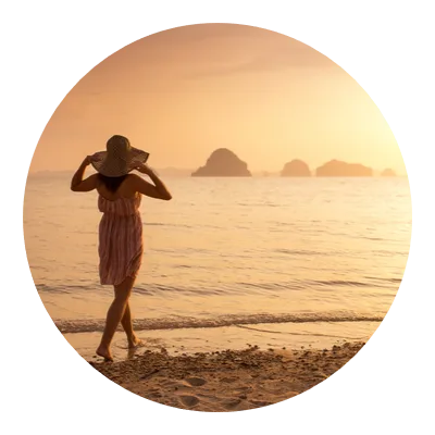 Frau am Strand bei Sonnenaufgang, Blick auf Horizont mit Felsen