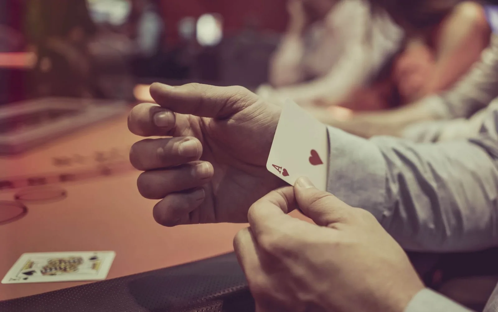 Lügen sicher erkennen – Videokurs zum Profiling 2 Pokerspieler zeigt Spielkarten beim Bluffen – Symbolbild für Täuschungserkennung