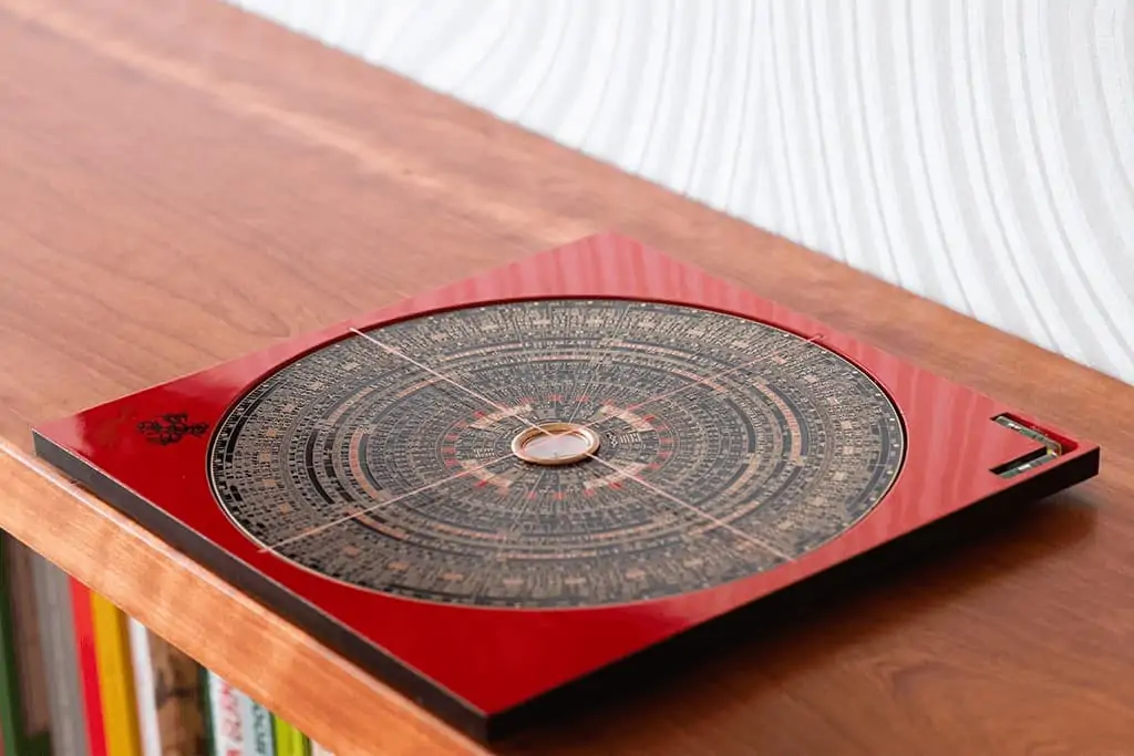 Nahaufnahme des roten Feng Shui Luo Pan Kompasses mit kreisförmigen Ringen und Symbolen
