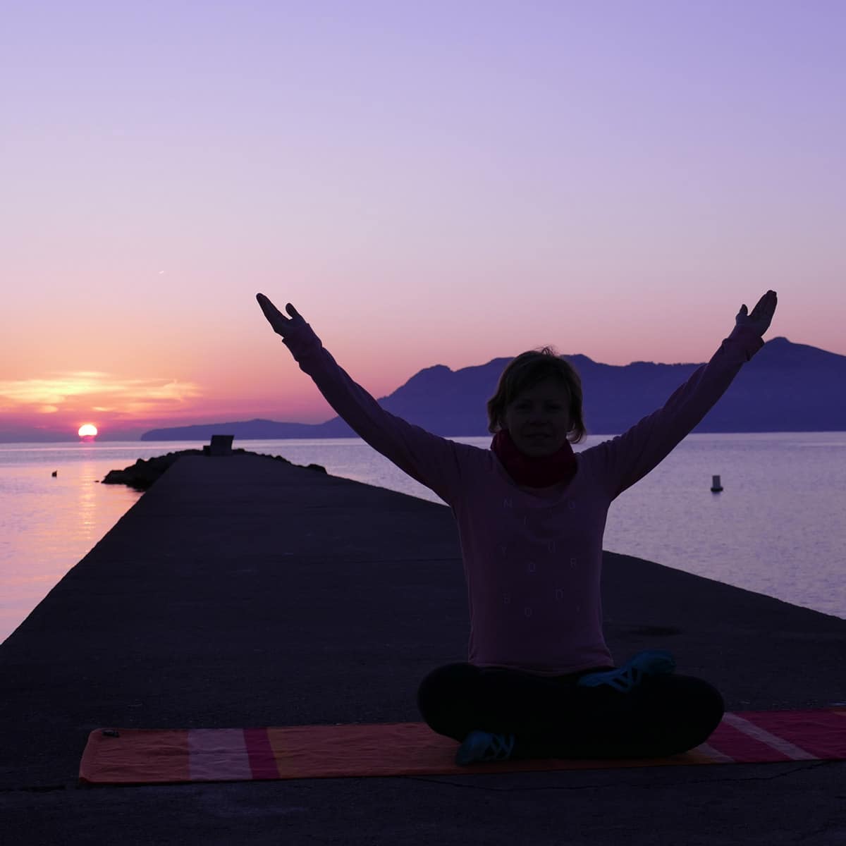 Magische Rauhnächte – Yoga- und Meditationskurs von Yoga mit Martina 1 Frau mit ausgebreiteten Armen bei Sonnenaufgang am Meer, Befreiungspose bei Rauhnacht-Ritual