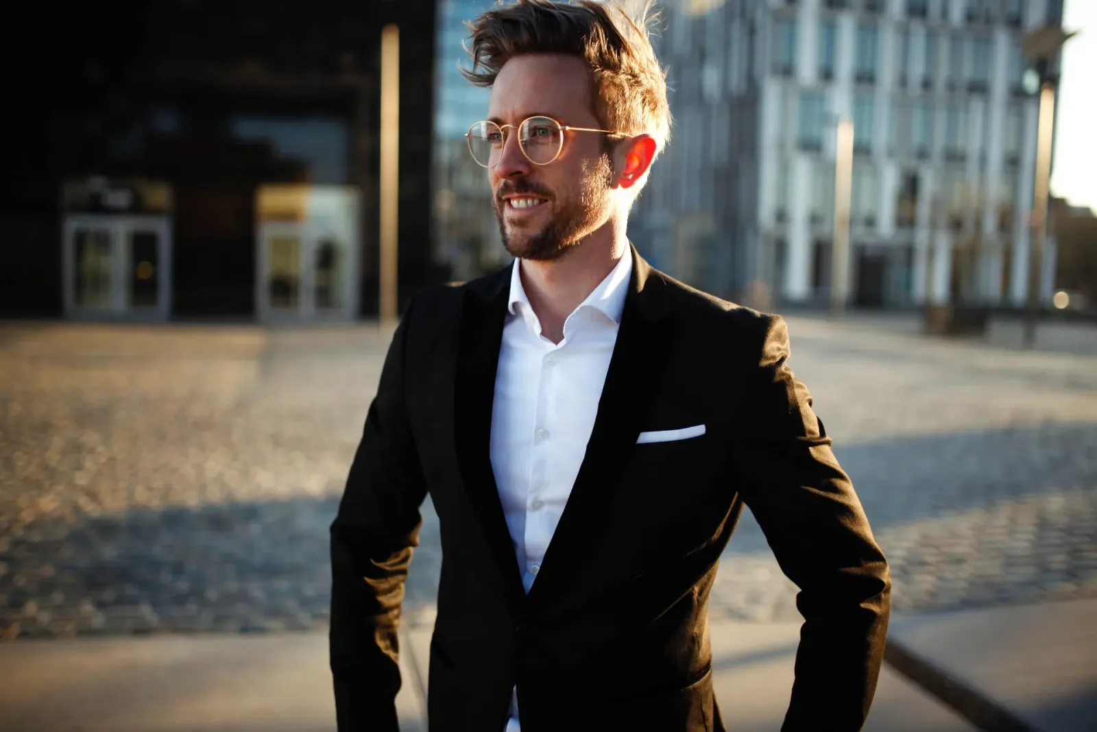 Marketing MasterClass – Videokurs zu Positionierung und Marke 10 Felix Thönnessen in Anzug mit Brille vor Urban-Hintergrund